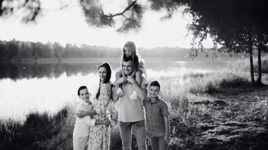 A joyful family enjoying time by the lake in a serene setting.